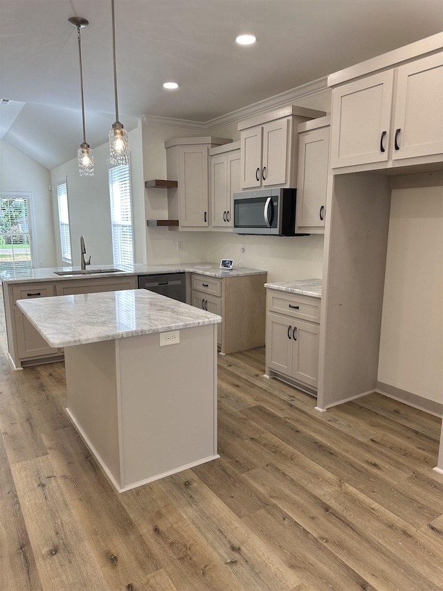 kitchen featuring decorative light fixtures, a center island, sink, and stainless steel appliances