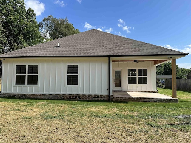 rear view of house with ceiling fan, a yard, and a patio