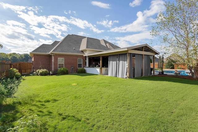 back of property with a yard and a swimming pool