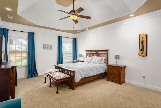 carpeted bedroom featuring ceiling fan, a raised ceiling, and crown molding