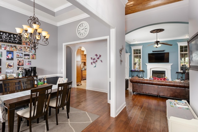 dining space featuring crown molding, ceiling fan with notable chandelier, and dark hardwood / wood-style floors