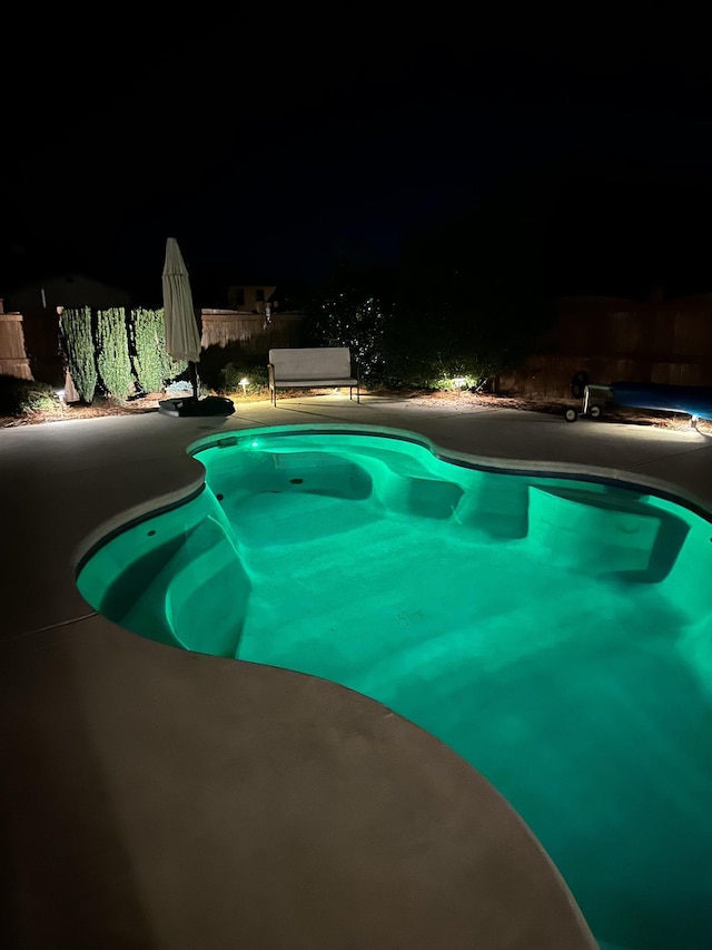 view of pool at twilight