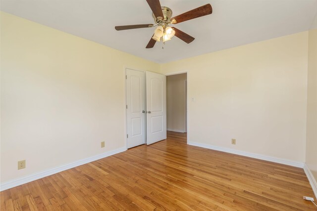 empty room featuring baseboards, light wood-style flooring, and a ceiling fan