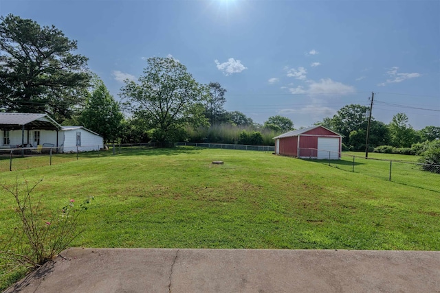 view of yard featuring a garage, an outbuilding, and driveway