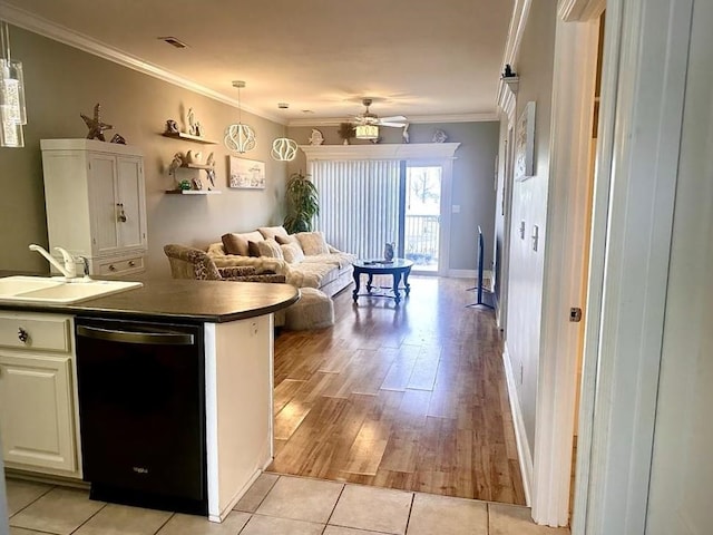 kitchen with sink, crown molding, dishwasher, white cabinets, and decorative light fixtures