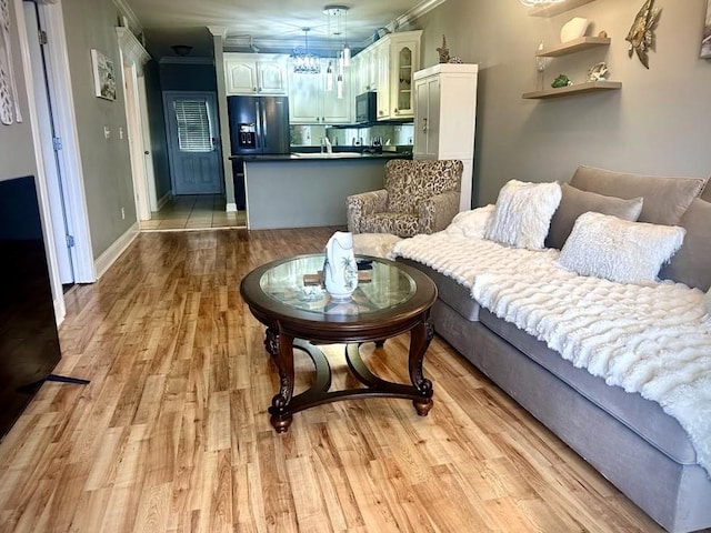 living room with crown molding and light hardwood / wood-style flooring