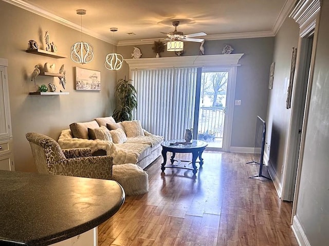 living room featuring wood-type flooring, ornamental molding, and ceiling fan