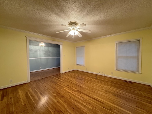 unfurnished room featuring wood-type flooring, a textured ceiling, ceiling fan, and ornamental molding