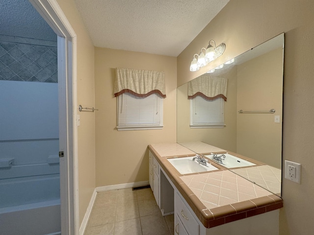 bathroom with tile patterned floors, vanity, and a textured ceiling