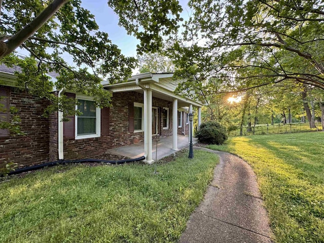 view of side of home featuring a lawn and a porch