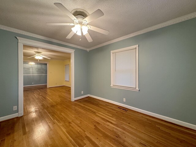 spare room featuring a textured ceiling, ceiling fan, crown molding, and hardwood / wood-style floors