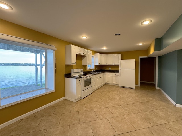 kitchen featuring white appliances, a water view, white cabinetry, and sink