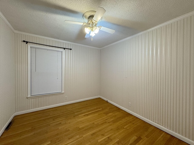 spare room with wood-type flooring, a textured ceiling, ceiling fan, and crown molding