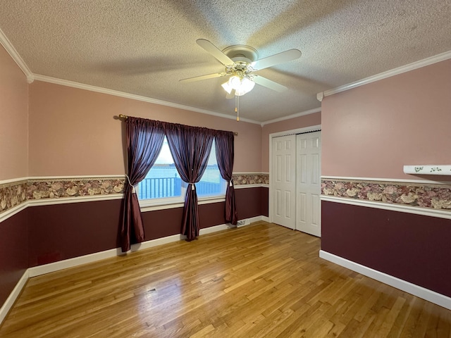 unfurnished room featuring a textured ceiling, ceiling fan, and ornamental molding