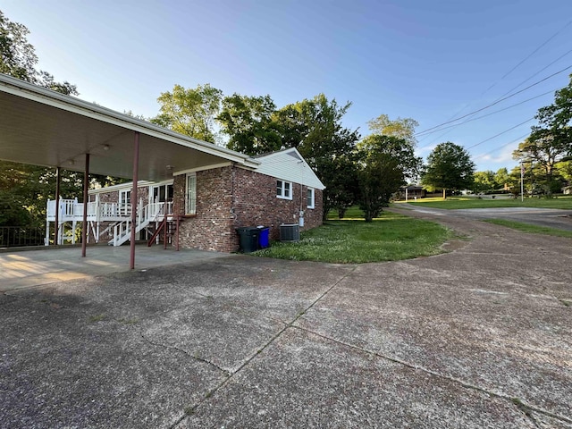 view of home's exterior with a porch, cooling unit, and a yard