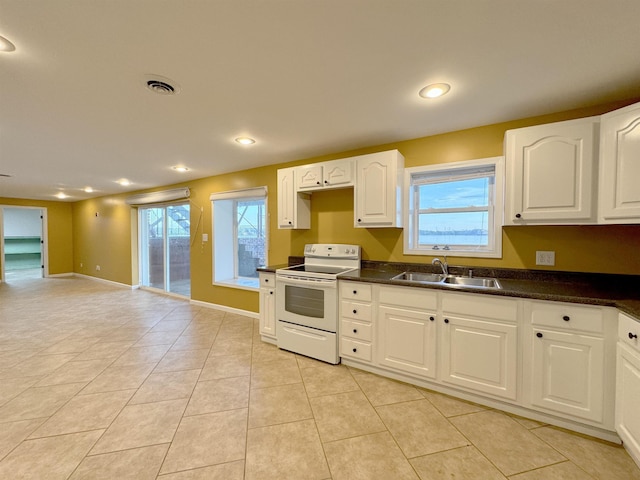 kitchen featuring white electric range oven, white cabinetry, sink, and light tile patterned floors