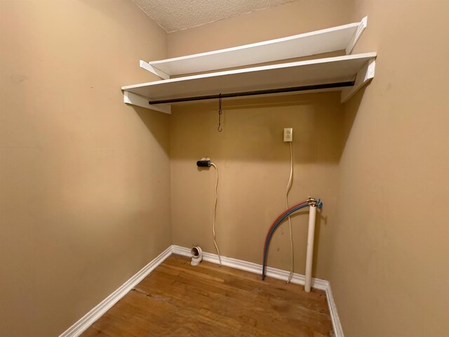 washroom featuring washer hookup, a textured ceiling, and hardwood / wood-style floors