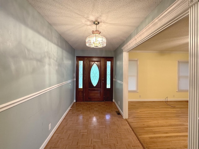 entryway featuring parquet flooring, a textured ceiling, and a chandelier