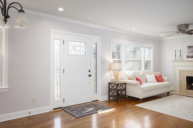 entrance foyer with a fireplace, dark wood-type flooring, and ornamental molding