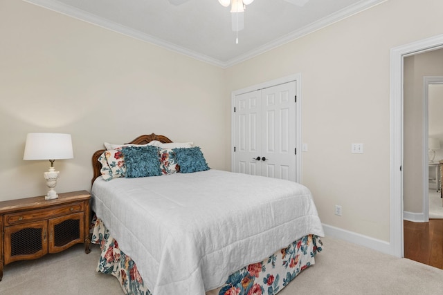 carpeted bedroom with crown molding, ceiling fan, and a closet