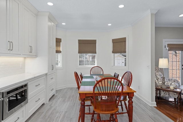 dining area featuring crown molding, plenty of natural light, and light hardwood / wood-style floors