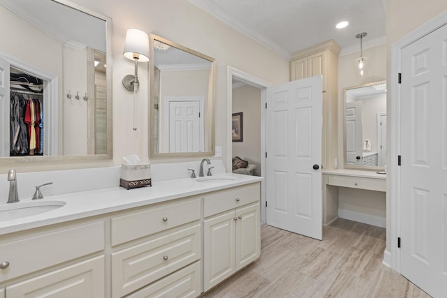 bathroom featuring ornamental molding, wood-type flooring, and vanity