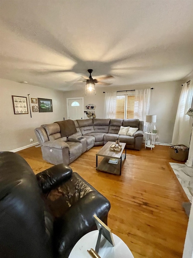 living room featuring ceiling fan, wood finished floors, and plenty of natural light