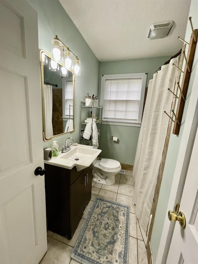 bathroom with tile patterned floors, toilet, vanity, a textured ceiling, and curtained shower