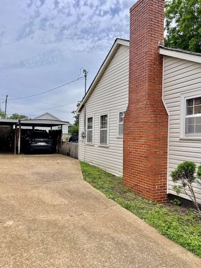 view of property exterior featuring a chimney and fence