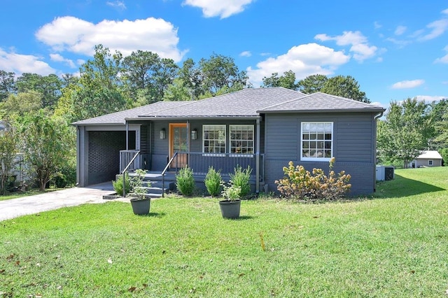 view of front of house with a shingled roof, a front yard, concrete driveway, and brick siding