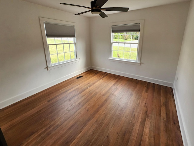 unfurnished room featuring a healthy amount of sunlight, baseboards, and dark wood-style flooring