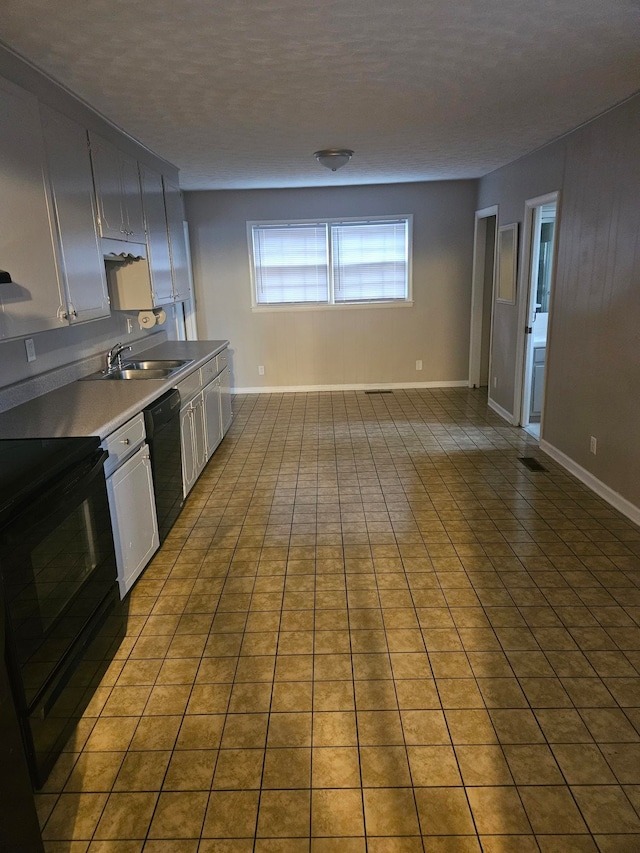 kitchen with tile patterned flooring, white cabinets, black appliances, and sink