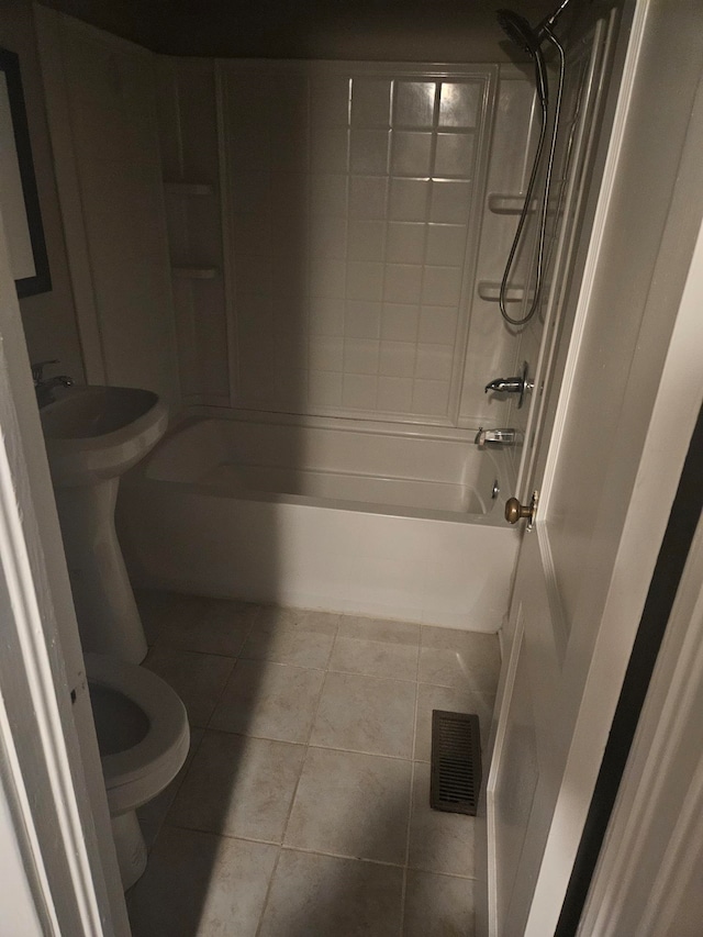 bathroom with tile patterned floors, washtub / shower combination, and toilet