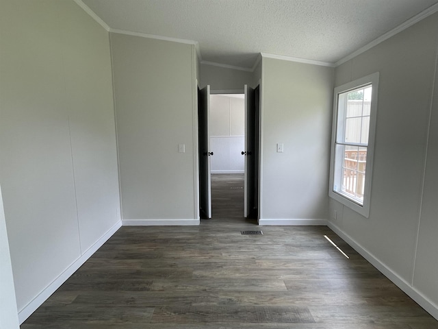 unfurnished room featuring a textured ceiling, dark hardwood / wood-style flooring, and crown molding