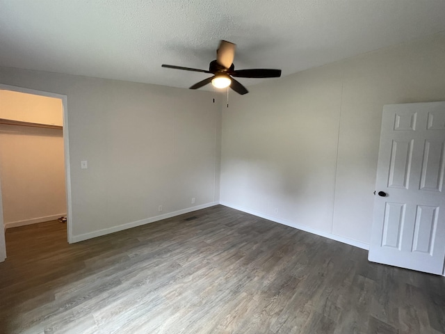 unfurnished room featuring a textured ceiling, dark hardwood / wood-style flooring, and ceiling fan