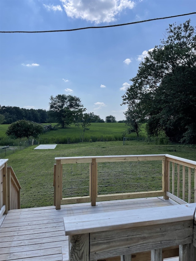 wooden terrace with a rural view and a yard