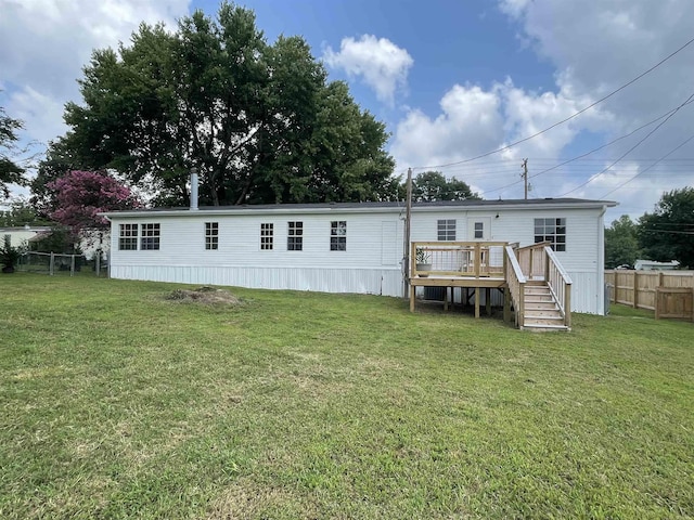 rear view of property featuring a yard and a wooden deck