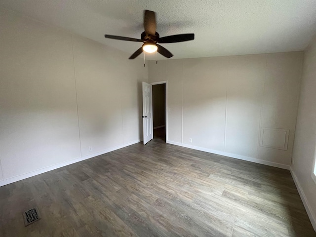 empty room featuring ceiling fan, dark hardwood / wood-style flooring, and a textured ceiling