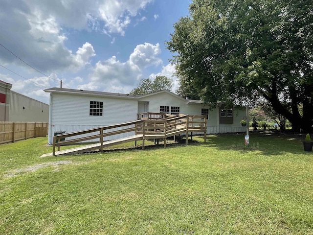 rear view of property with a deck and a yard