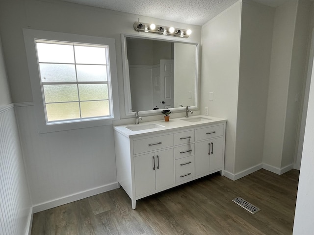 bathroom featuring hardwood / wood-style flooring, vanity, and a textured ceiling