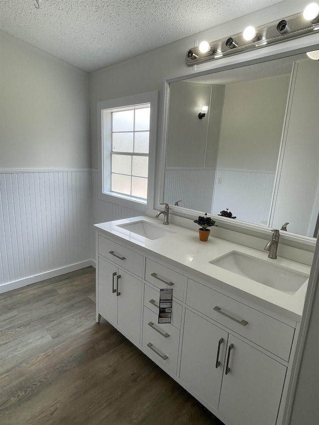 bathroom with vanity, wood-type flooring, and a textured ceiling