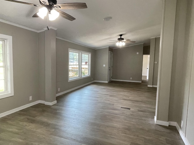 empty room with ceiling fan, dark hardwood / wood-style flooring, and crown molding