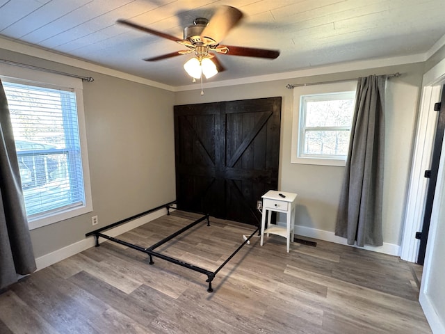 bedroom with crown molding, wood-type flooring, and ceiling fan