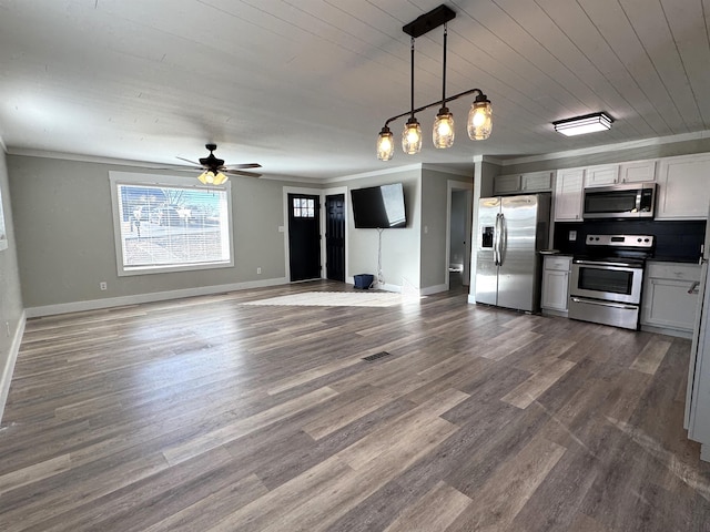 kitchen with crown molding, appliances with stainless steel finishes, pendant lighting, and dark hardwood / wood-style flooring