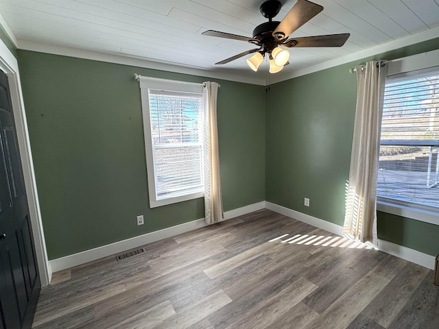 empty room with wood-type flooring, ornamental molding, wooden ceiling, and ceiling fan