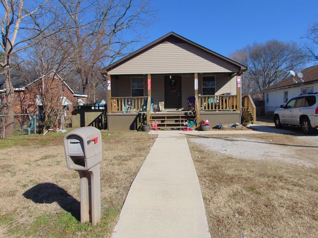 bungalow-style home featuring covered porch and a front yard