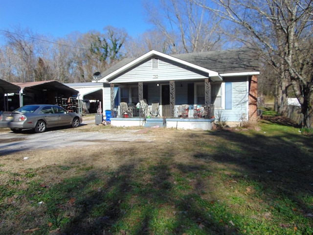 view of front of house with a porch, a carport, and a front lawn