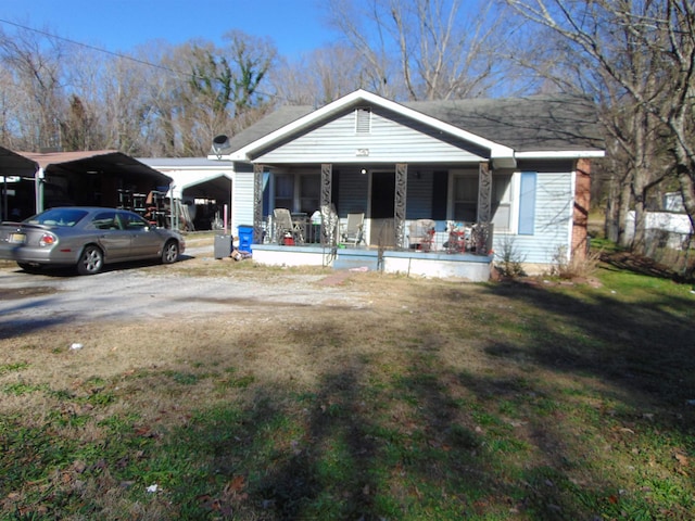 view of front of home featuring a porch, a carport, and a front lawn