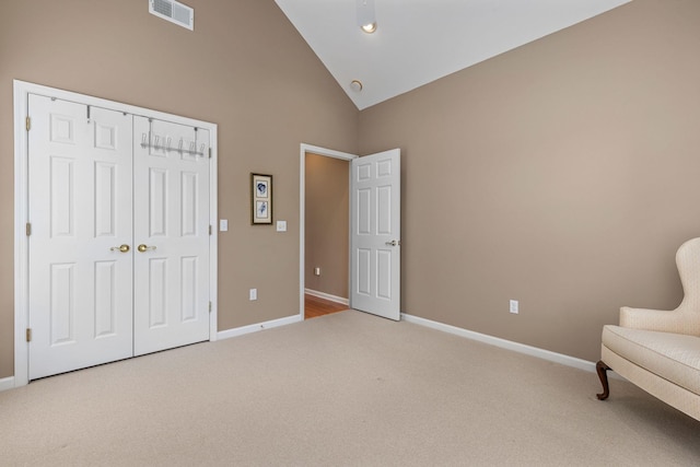  - living area with carpet flooring, baseboards, and high vaulted ceiling
