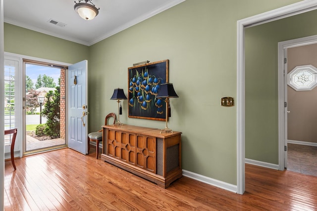  - foyer entrance featuring hardwood / wood-style floors, crown molding, and baseboards